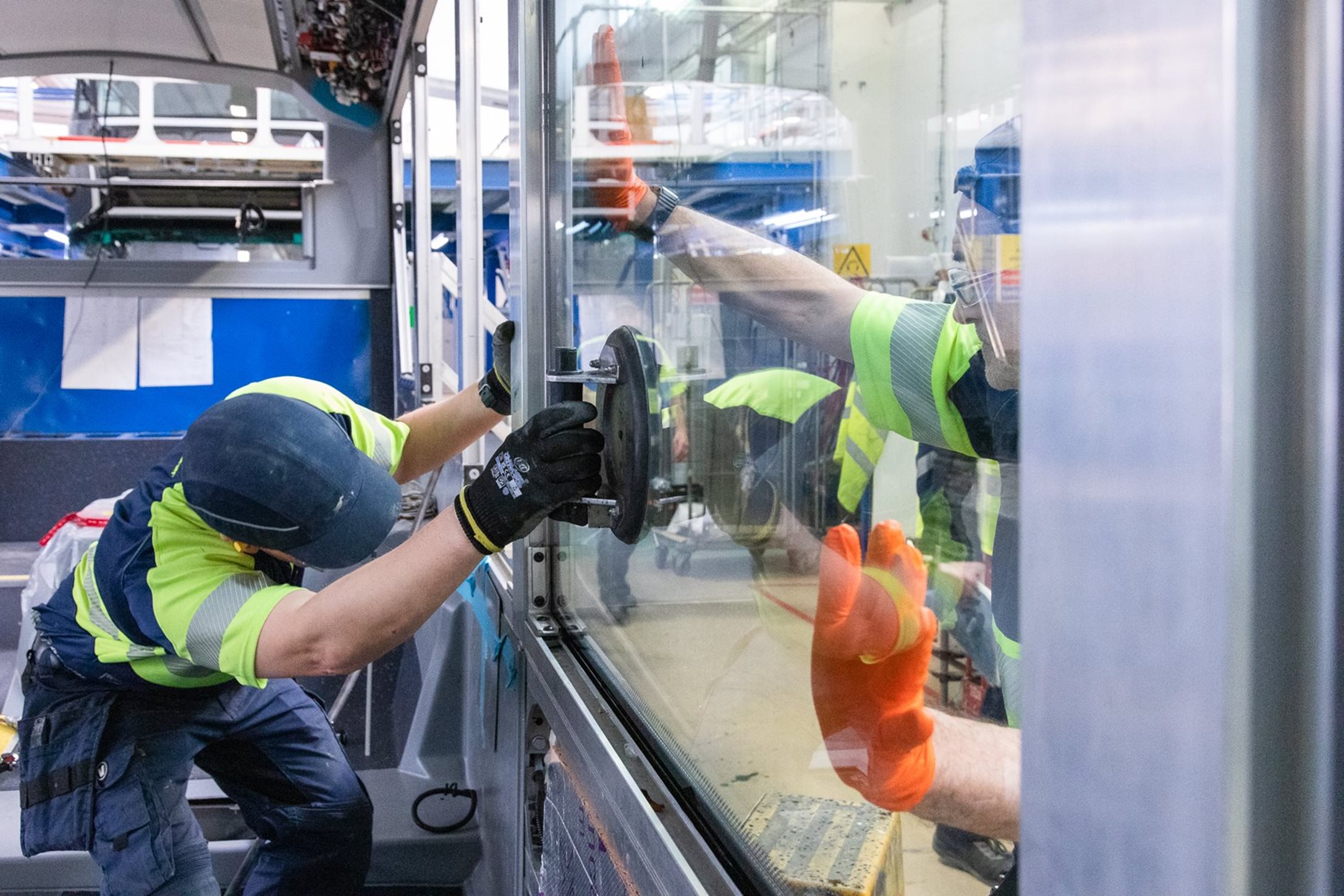 Engineers installing windows in Foyle Metro zero emission buses