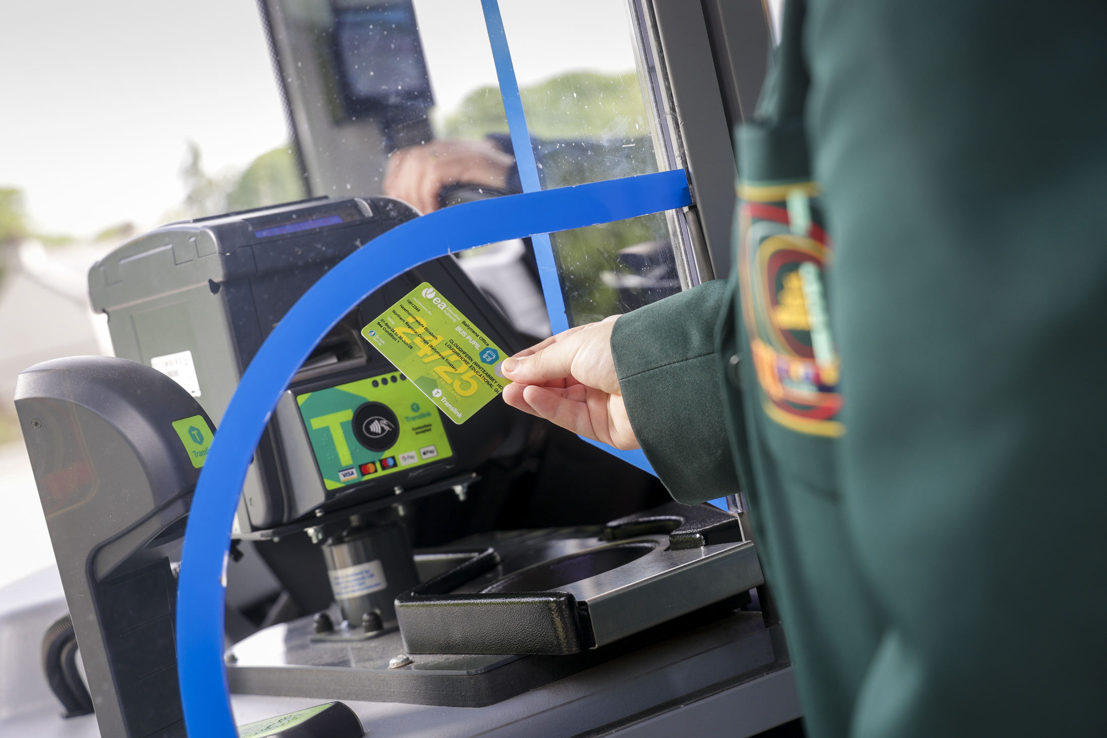A photo showing a school pupil using a travel card to board a bus
