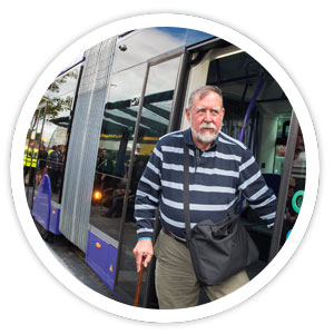 A Senior SmartPass user steps off a Glider bus in Belfast City Centre